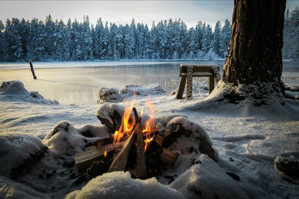 Scene of campfire at mountain lake in winter